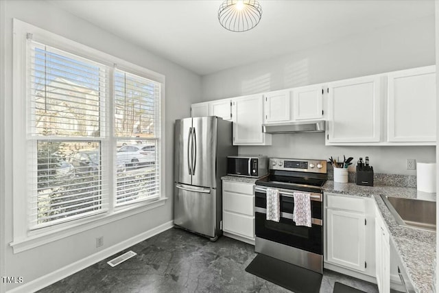 kitchen with under cabinet range hood, stainless steel appliances, plenty of natural light, and visible vents