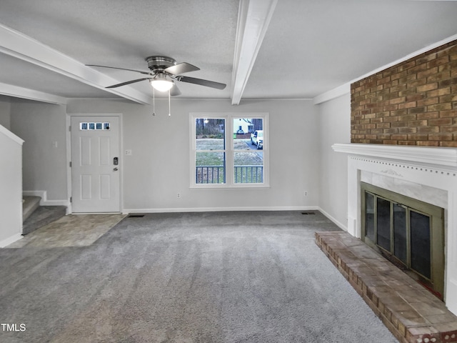 unfurnished living room with beamed ceiling, a large fireplace, carpet floors, baseboards, and stairs