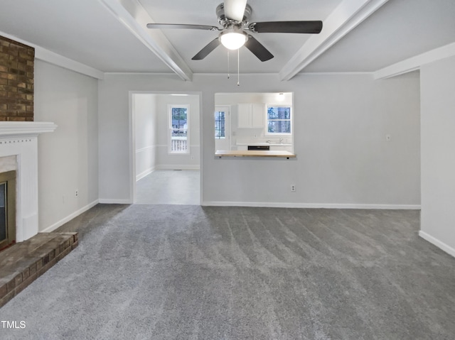 unfurnished living room featuring baseboards, a fireplace, ceiling fan, beamed ceiling, and dark colored carpet