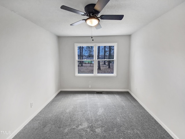 unfurnished room featuring carpet flooring, a textured ceiling, baseboards, and a ceiling fan