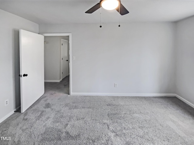 spare room featuring baseboards, a ceiling fan, and carpet floors