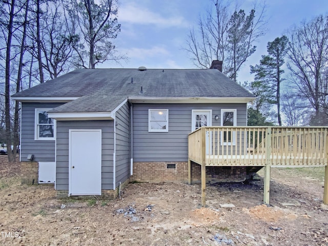 rear view of house featuring a wooden deck, a chimney, roof with shingles, and crawl space