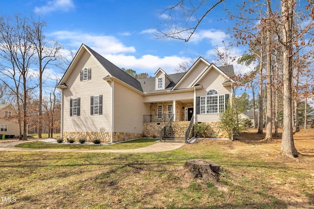 traditional-style home featuring stone siding, a porch, and a front yard