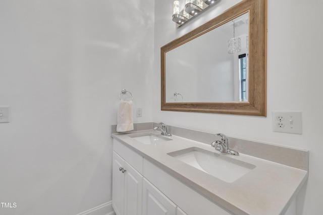 bathroom featuring a sink, baseboards, and double vanity