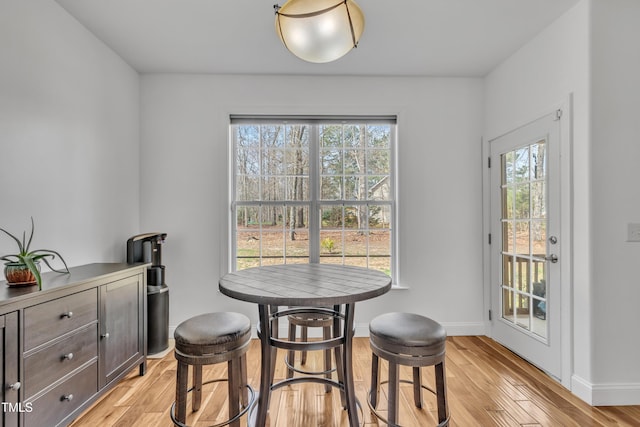 dining space with light wood-style floors and baseboards