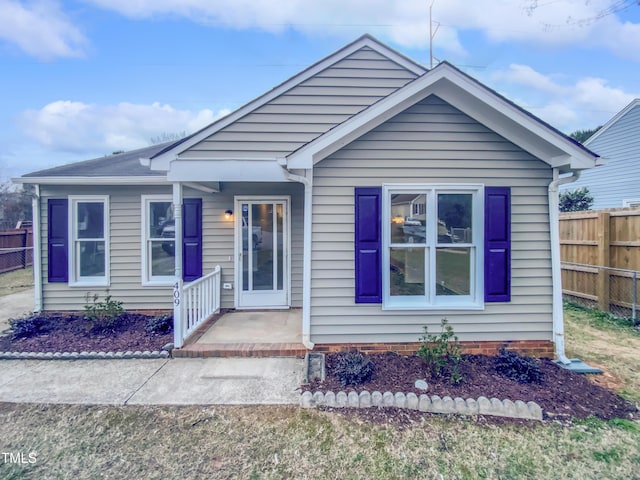 bungalow-style home with fence