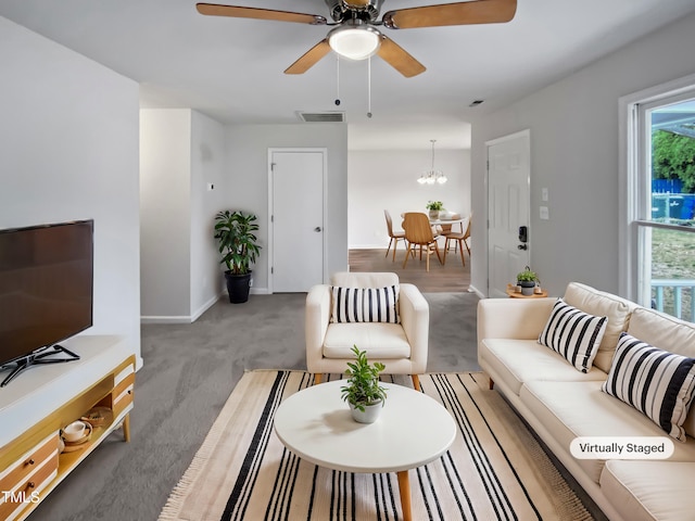 carpeted living area with visible vents, a ceiling fan, and baseboards