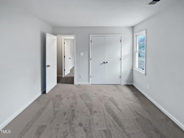 unfurnished bedroom with carpet flooring, baseboards, and a closet