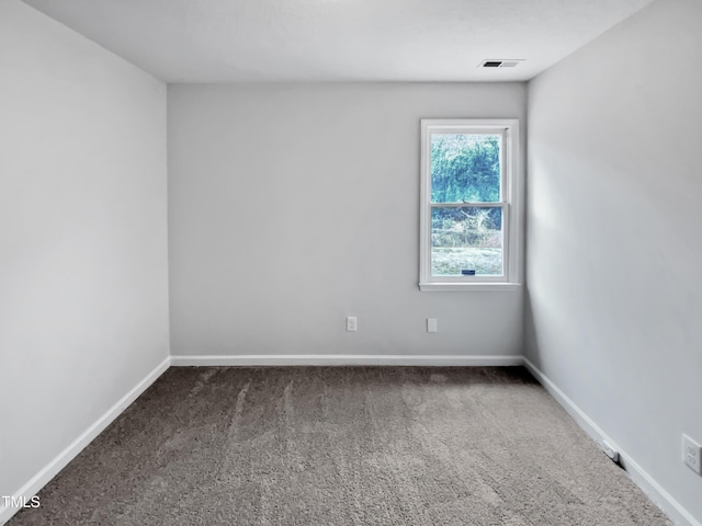 carpeted spare room featuring visible vents and baseboards