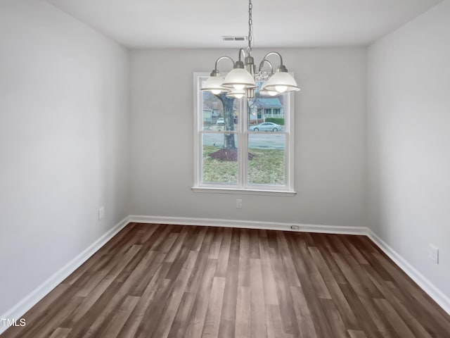 unfurnished dining area with dark wood-style floors, visible vents, an inviting chandelier, and baseboards