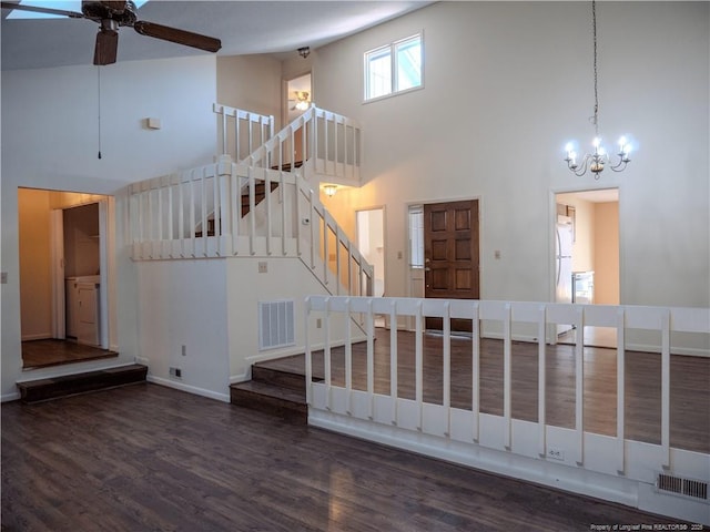 stairway with visible vents, ceiling fan with notable chandelier, high vaulted ceiling, and wood finished floors