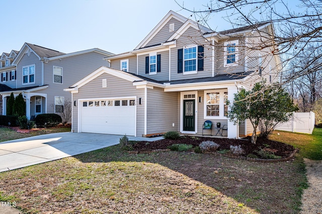 view of front of home with a garage, concrete driveway, a front lawn, and fence