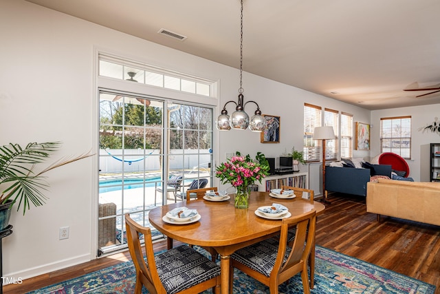 dining space featuring ceiling fan, visible vents, baseboards, and wood finished floors