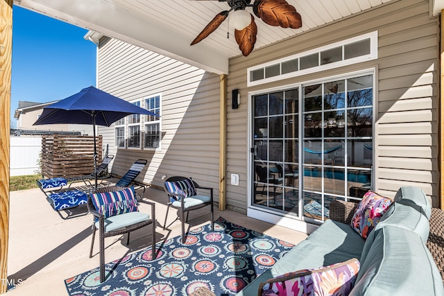 view of patio featuring outdoor lounge area, fence, and ceiling fan