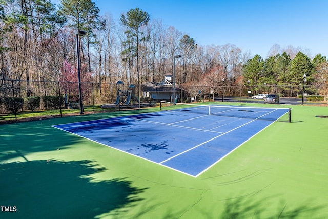 view of sport court with playground community and fence