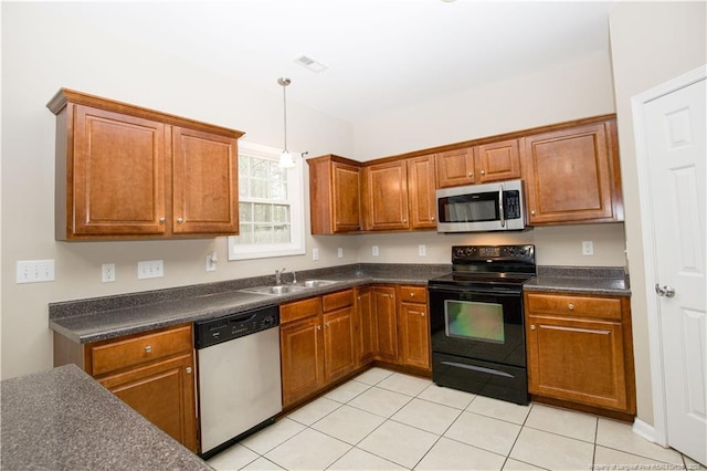 440 Moss Pink Dr, Vass, NC 28394 - kitchen with a sink, appliances with stainless steel finishes, hanging light fixtures, brown cabinetry, and dark countertops