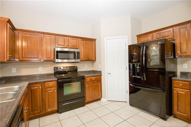 440 Moss Pink Dr, Vass, NC 28394 - kitchen with light tile patterned floors, a sink, dark countertops, black appliances, and brown cabinets