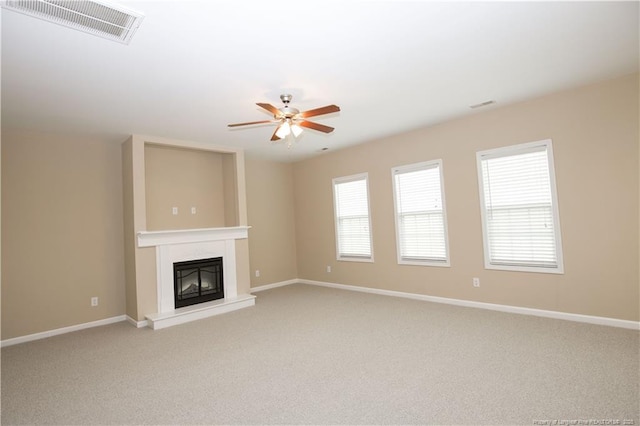 440 Moss Pink Dr, Vass, NC 28394 - unfurnished living room with visible vents, a glass covered fireplace, a ceiling fan, and light carpet