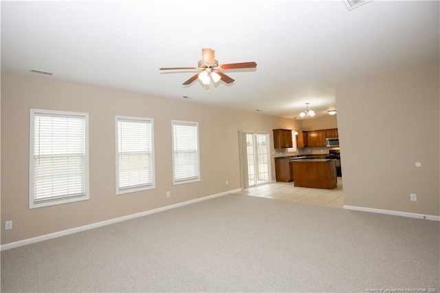 440 Moss Pink Dr, Vass, NC 28394 - unfurnished living room with light carpet, ceiling fan with notable chandelier, visible vents, and baseboards