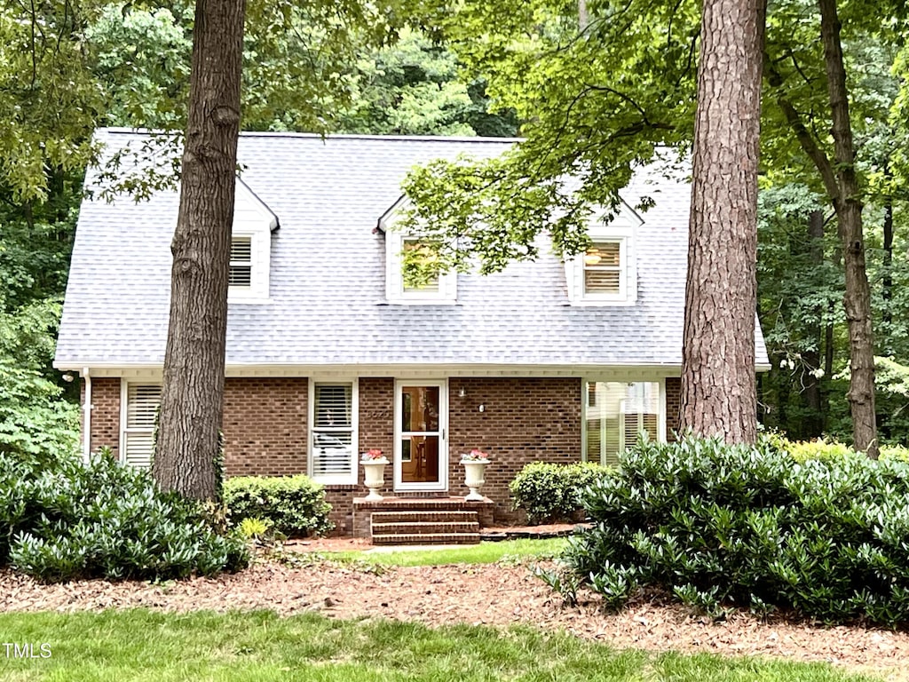 8620 Brookdale Dr, Raleigh, NC 27613 - new england style home featuring brick siding and a shingled roof
