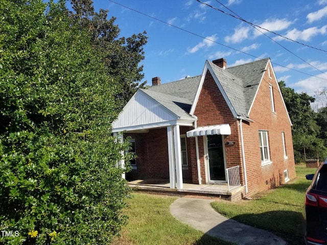 view of front of house with brick siding, roof with shingles, and a front yard