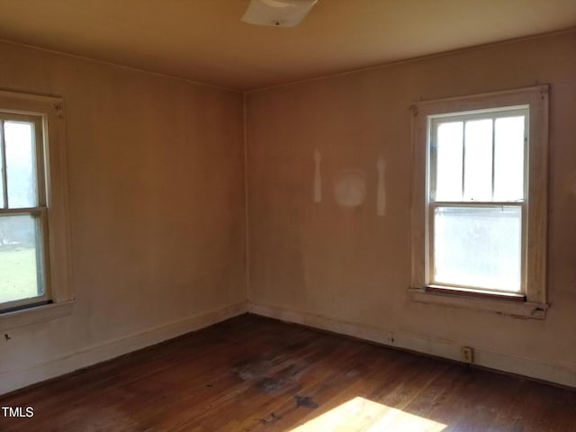 spare room with dark wood-type flooring and baseboards