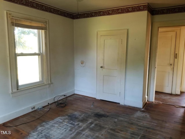 empty room featuring wood finished floors and baseboards