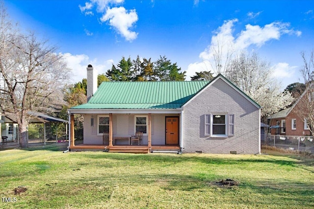 view of front of house featuring a porch, a front yard, crawl space, brick siding, and a chimney