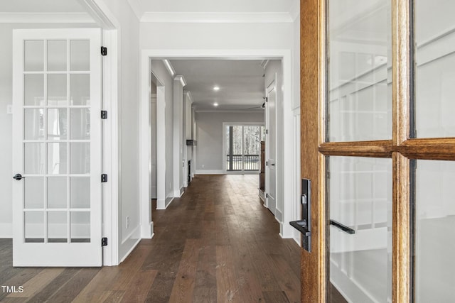 hallway with dark wood finished floors, crown molding, and baseboards