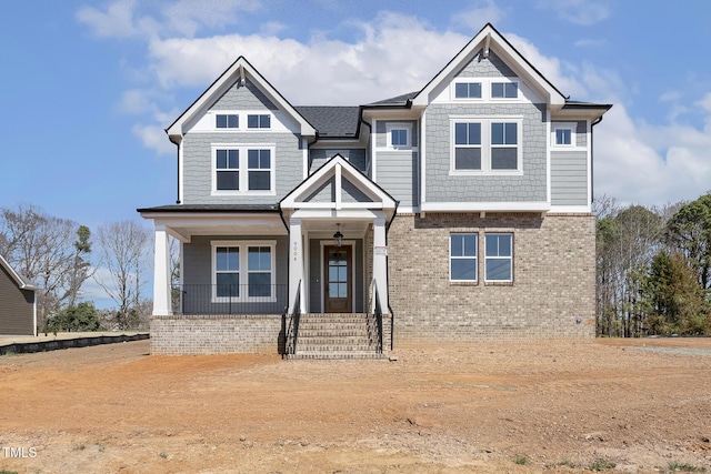 view of front of home with brick siding and covered porch