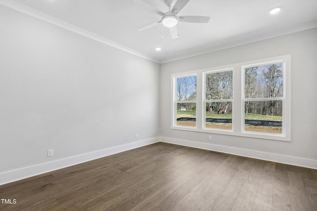 spare room featuring baseboards, a ceiling fan, ornamental molding, and dark wood-style flooring