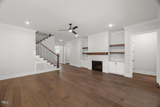 9004 Penny Rd, Raleigh, NC 27606 - unfurnished living room with ceiling fan, ornamental molding, dark wood-style floors, a fireplace, and stairway