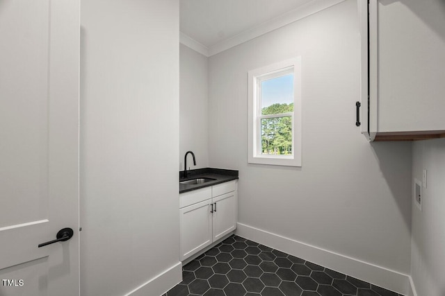 9004 Penny Rd, Raleigh, NC 27606 - laundry room featuring cabinet space, ornamental molding, and dark tile patterned flooring