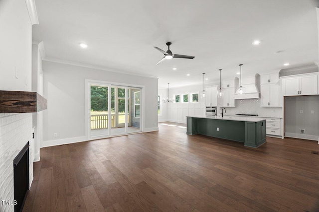 9004 Penny Rd, Raleigh, NC 27606 - unfurnished living room with a ceiling fan, a brick fireplace, crown molding, dark wood finished floors, and recessed lighting