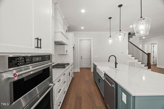 9004 Penny Rd, Raleigh, NC 27606 - kitchen with appliances with stainless steel finishes, crown molding, white cabinets, dark wood-type flooring, and an island with sink