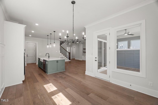 9004 Penny Rd, Raleigh, NC 27606 - kitchen with light countertops, ornamental molding, wood finished floors, a center island with sink, and recessed lighting