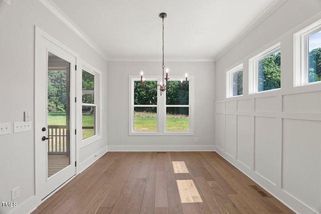 9004 Penny Rd, Raleigh, NC 27606 - unfurnished dining area featuring a chandelier, wood finished floors, and ornamental molding