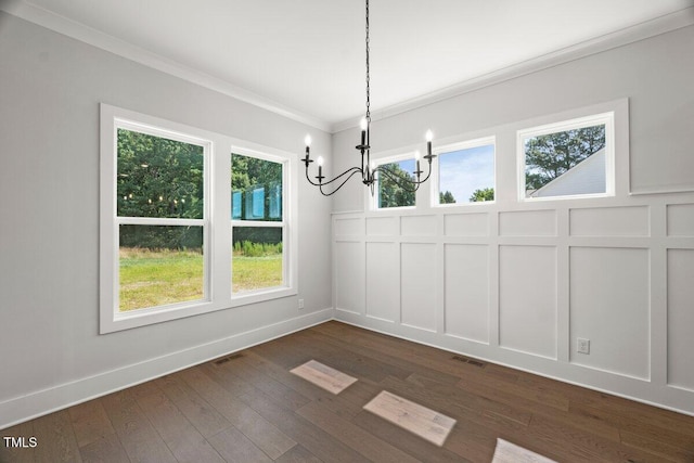 9004 Penny Rd, Raleigh, NC 27606 - unfurnished dining area featuring a chandelier, crown molding, dark wood finished floors, and a decorative wall