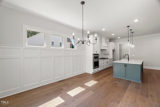 9004 Penny Rd, Raleigh, NC 27606 - kitchen featuring a decorative wall, stainless steel appliances, crown molding, a chandelier, and white cabinetry