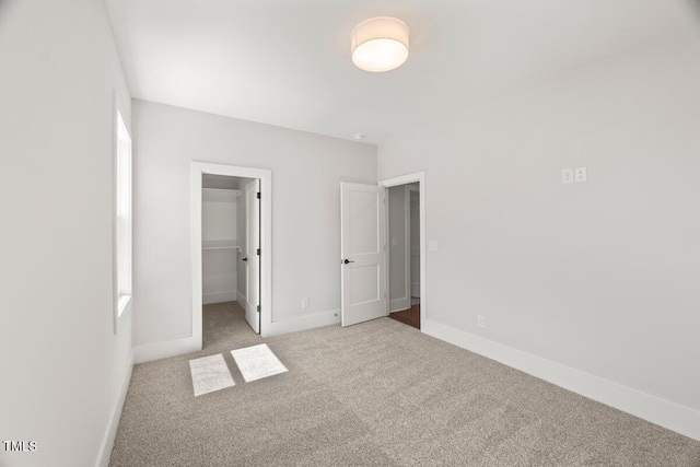 9004 Penny Rd, Raleigh, NC 27606 - unfurnished bedroom featuring carpet, a walk in closet, and a closet