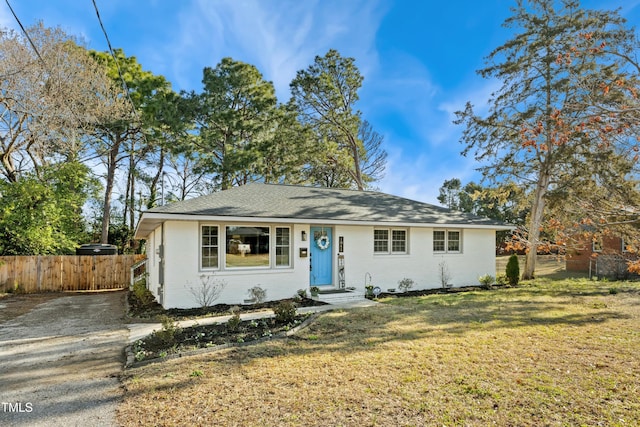 ranch-style home with a front lawn and fence