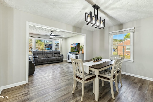 dining space with wood finished floors, baseboards, and a textured ceiling