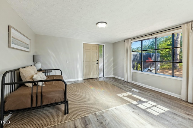 sitting room featuring a textured ceiling, baseboards, and wood finished floors