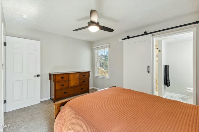 carpeted bedroom featuring baseboards, a barn door, and a ceiling fan