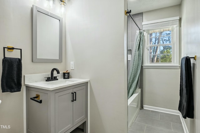 full bathroom with tile patterned floors, baseboards, shower / bath combo with shower curtain, and vanity