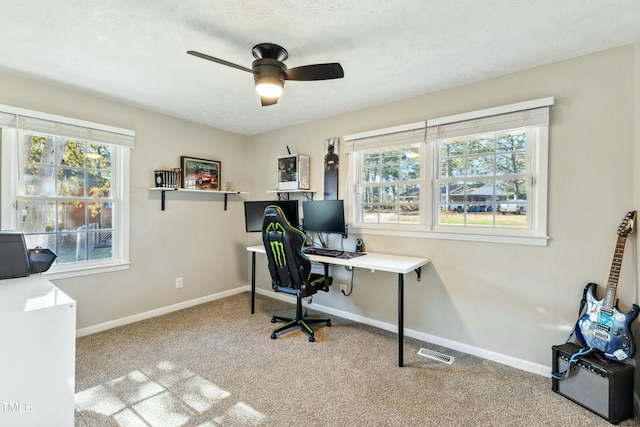 office space with a ceiling fan, visible vents, baseboards, a textured ceiling, and carpet flooring