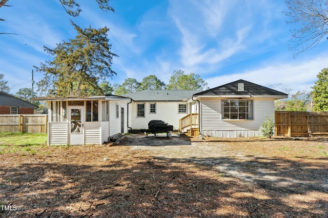 rear view of property with entry steps and fence