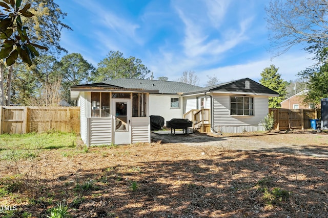 back of property featuring fence, entry steps, and a sunroom