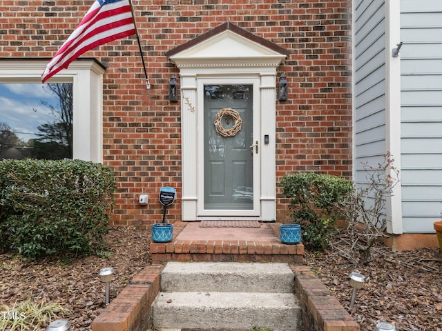 view of exterior entry featuring brick siding