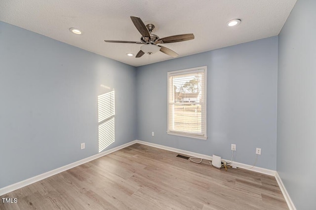 spare room featuring wood finished floors, baseboards, recessed lighting, ceiling fan, and a textured ceiling